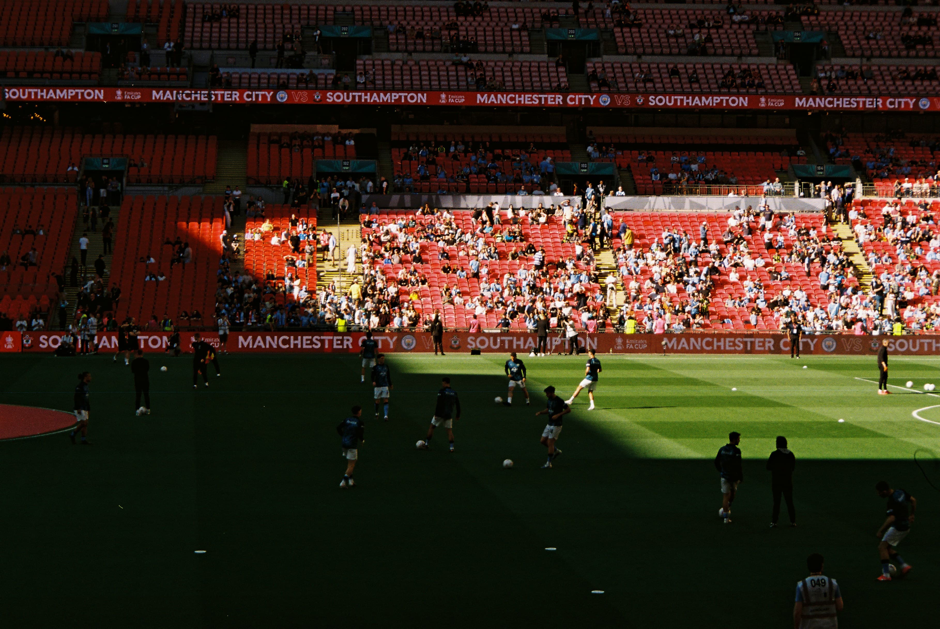 Football players warming up on a sunny pitch before a match