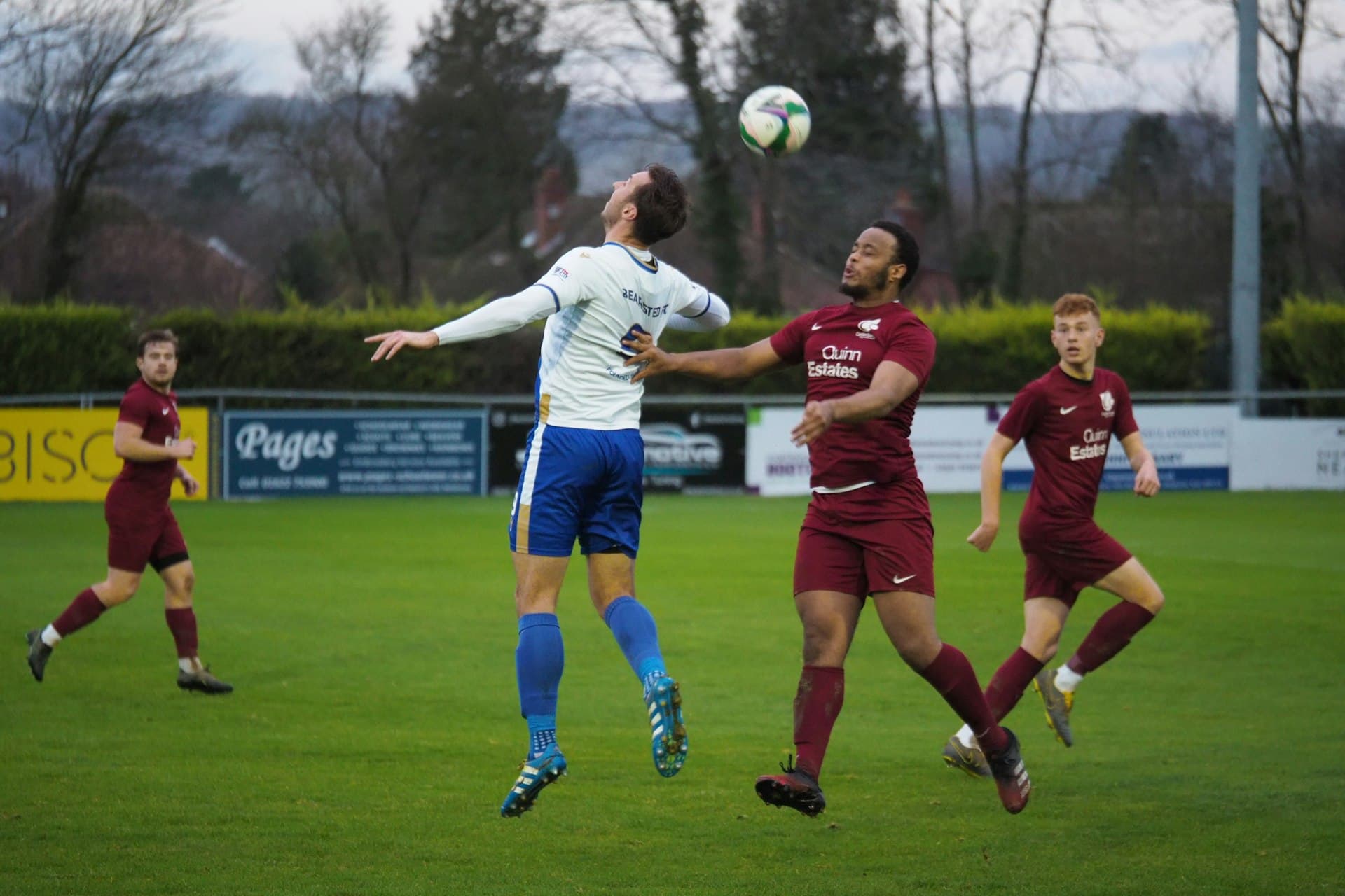 Players competing during a grassroots football match at a local ground