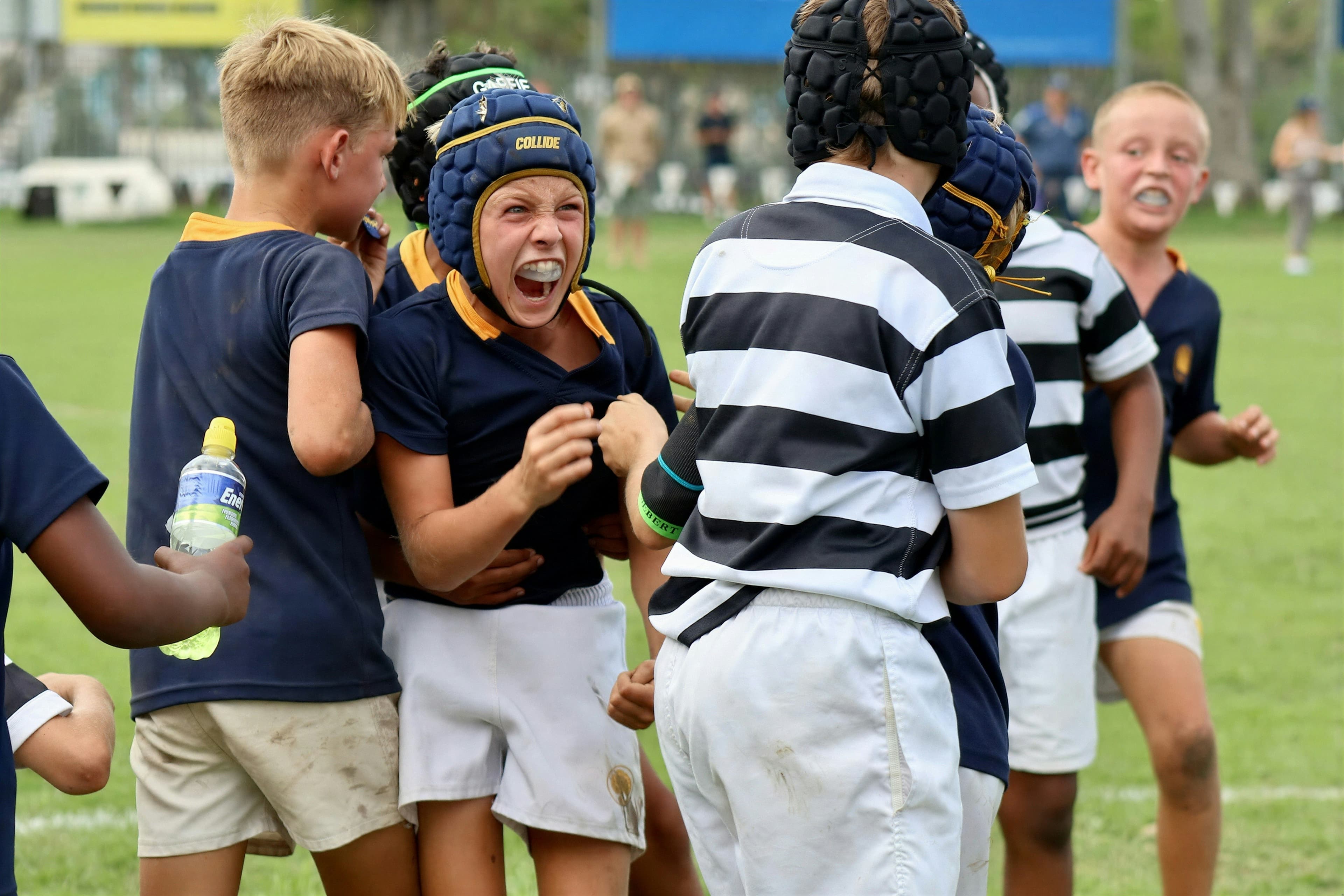 Young rugby players celebrating together on the pitch